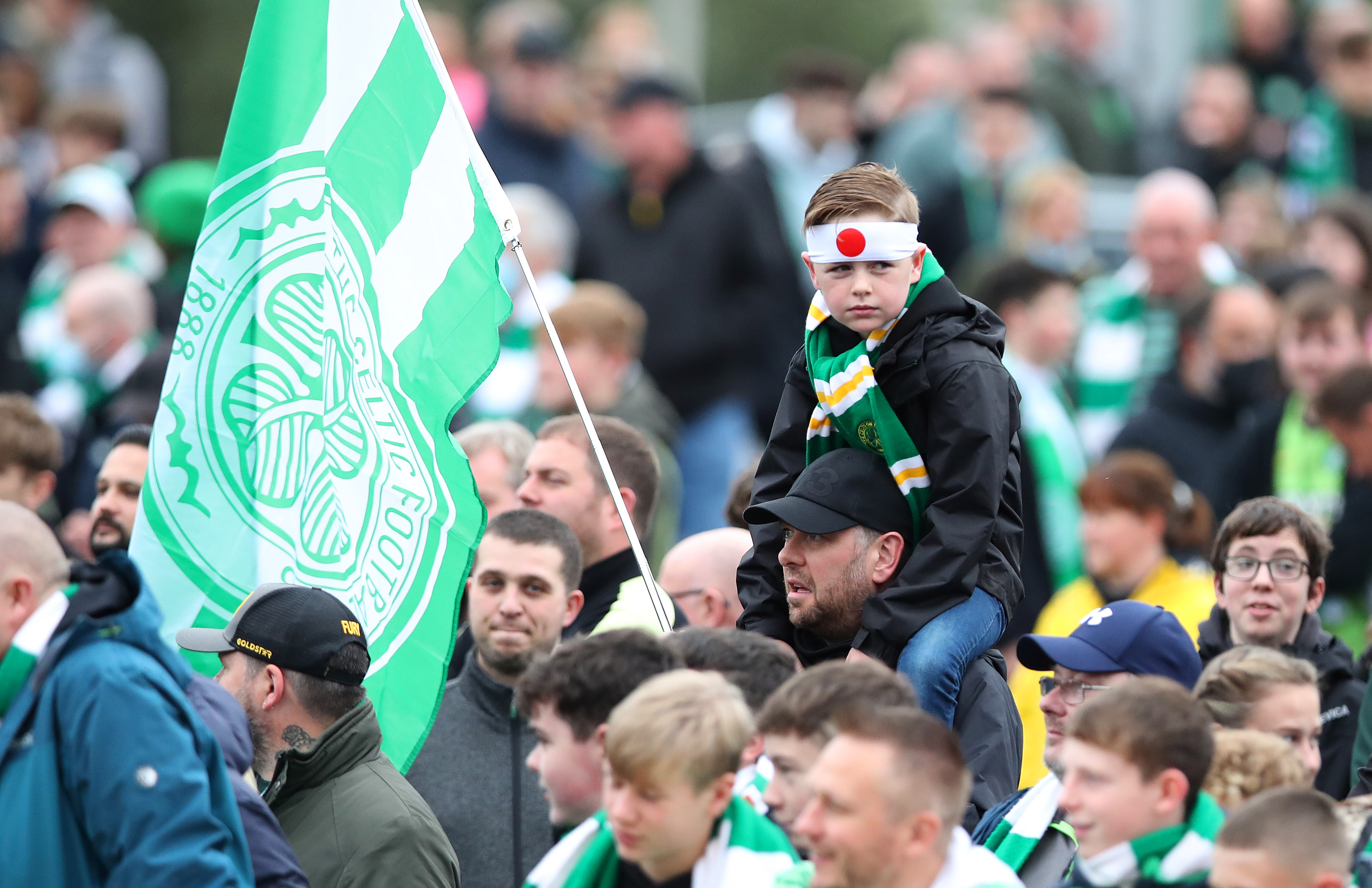 Fans of Ferencvarosi show their support as they hold scarves prior