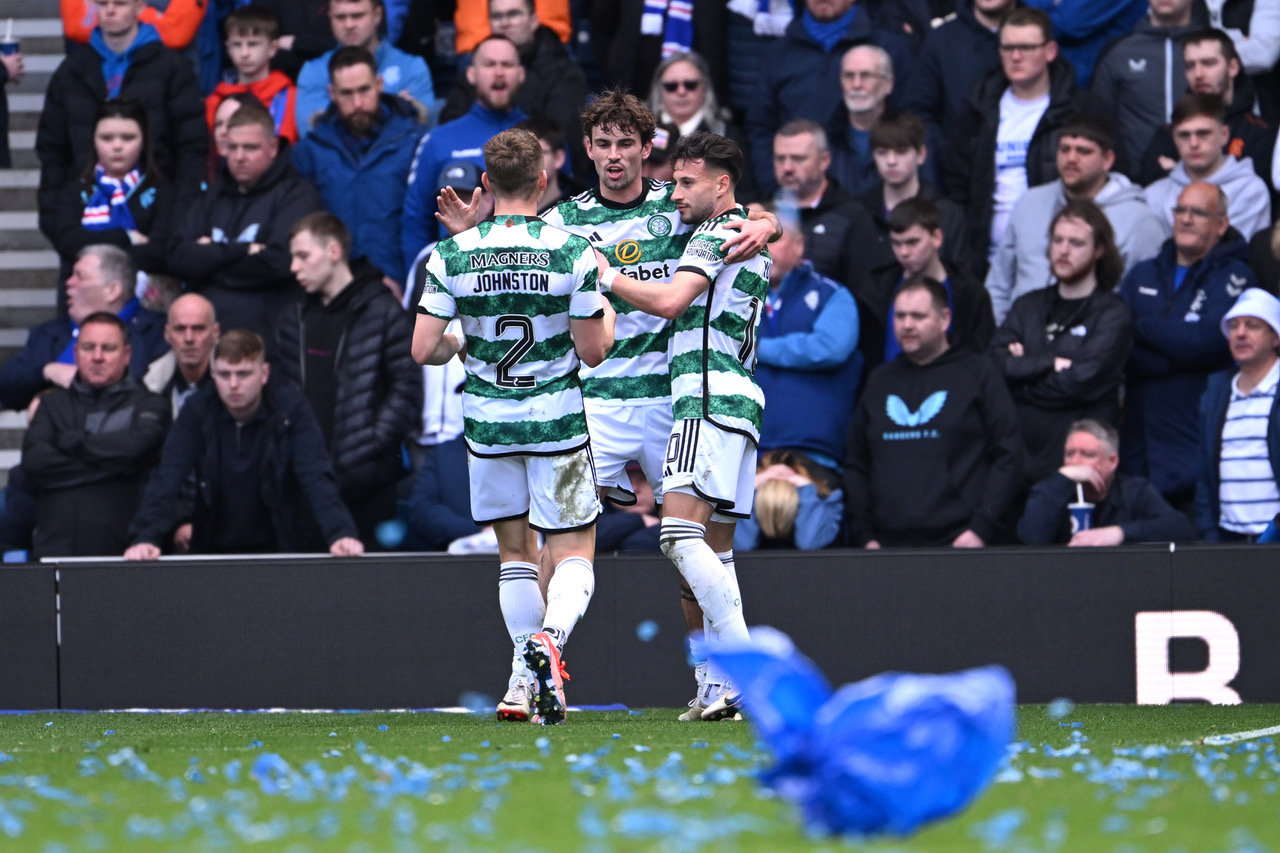Matt O'Riley celebrates with Celtic teammates at Ibrox