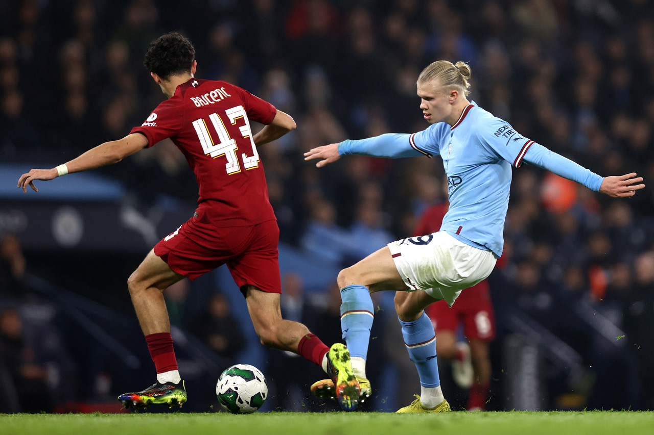 Erling Haaland of Manchester City holds off pressure from Stefan Bajcetic of Liverpool