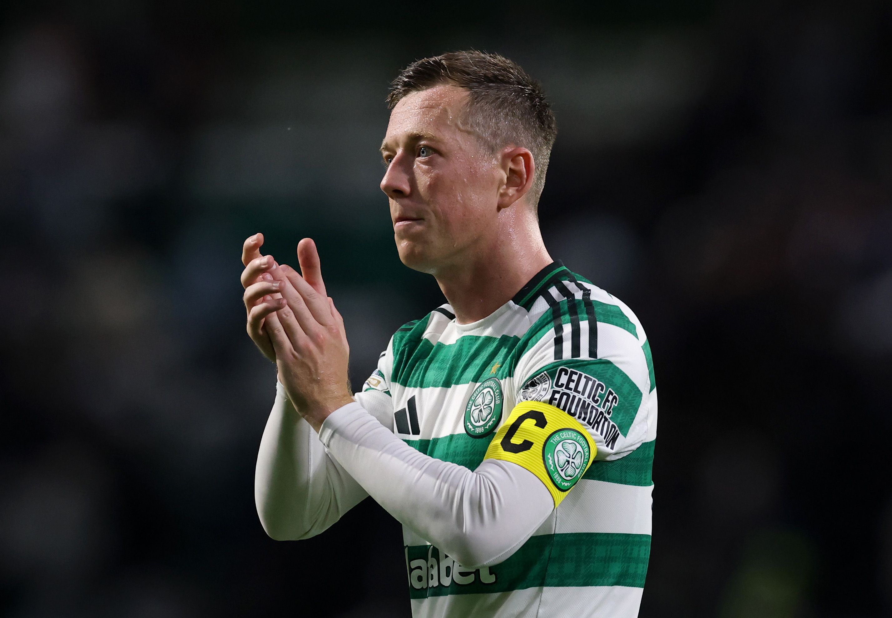 Callum McGregor applauds the fans