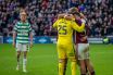 Hearts players celebrate as a dejected Liam Scales looks on