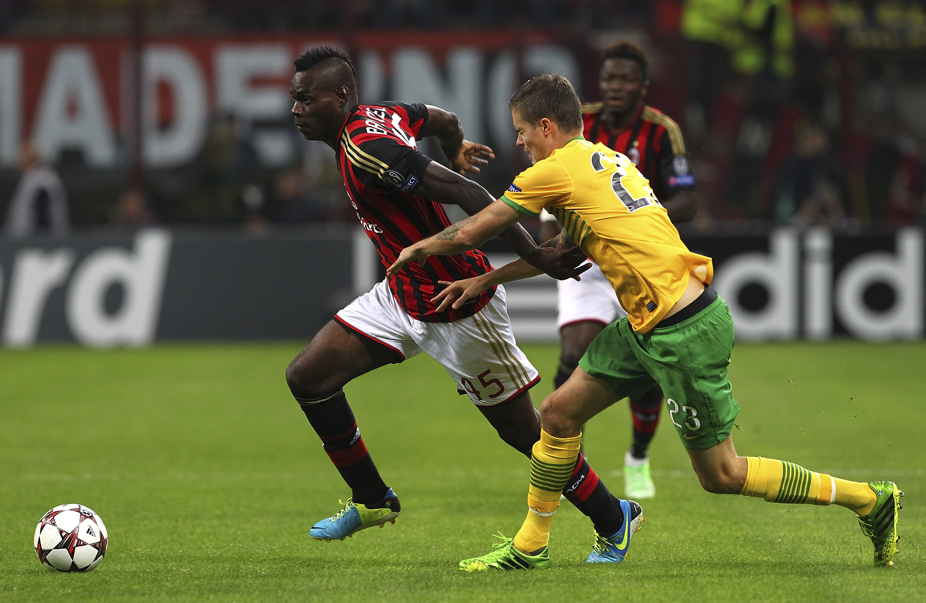 Mario Balotelli of AC Milan competes for the ball with Mikael Lustig of Celtic