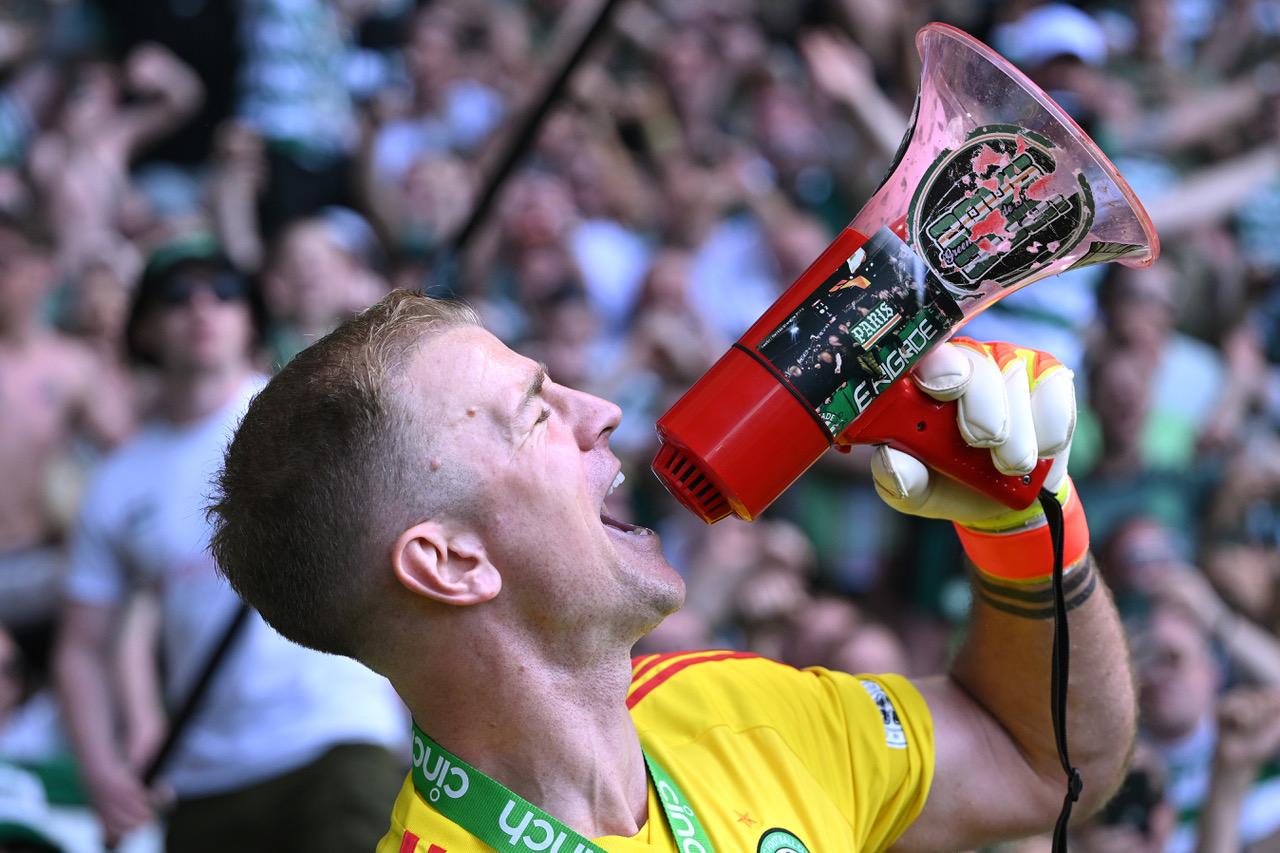 Celtic goalkeeper Joe Hart sings on the megaphone infront of the fans