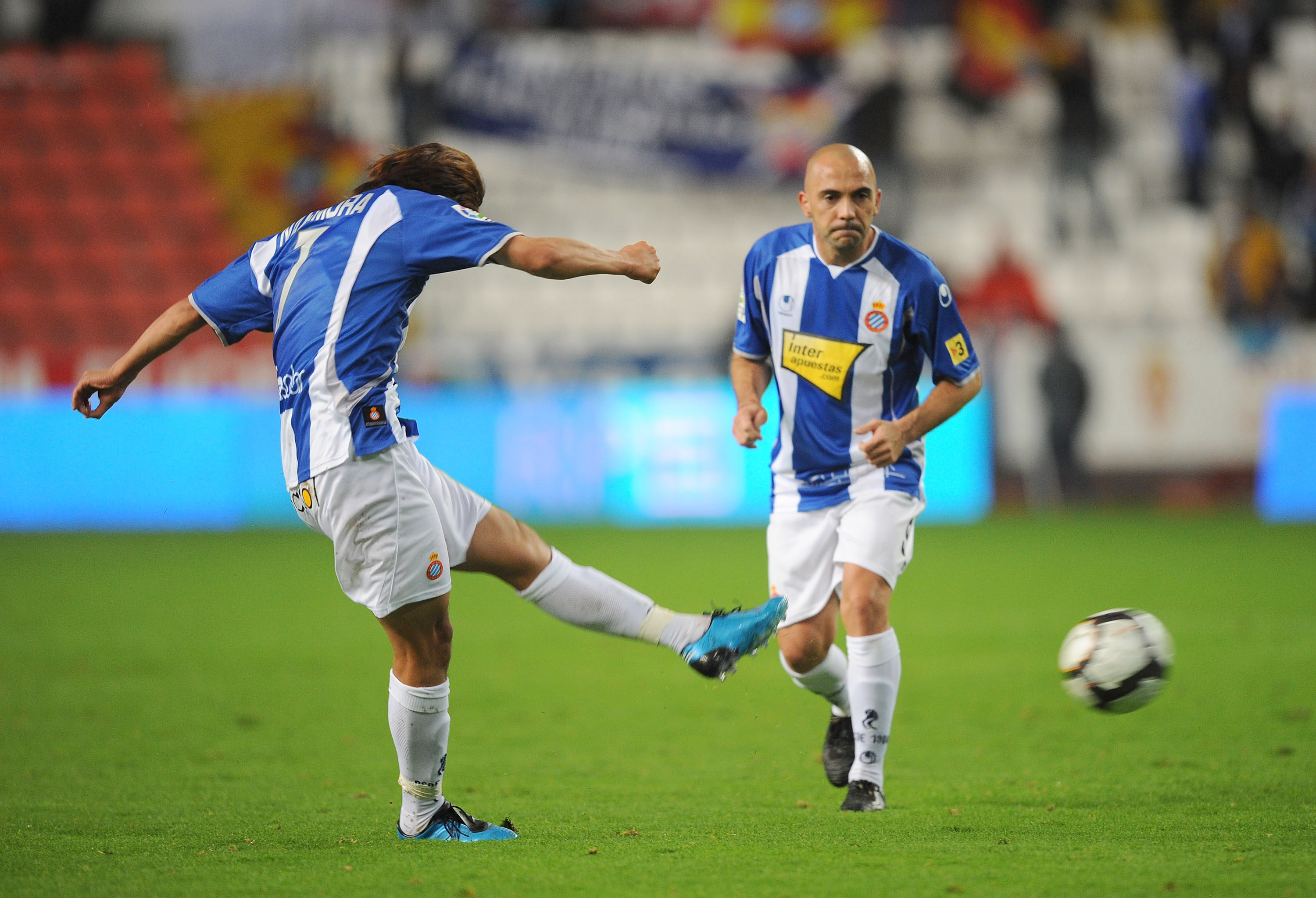 Shunsuke Nakamura (L) of Espanyol takes a free kick while Ivan de la Pena looks on